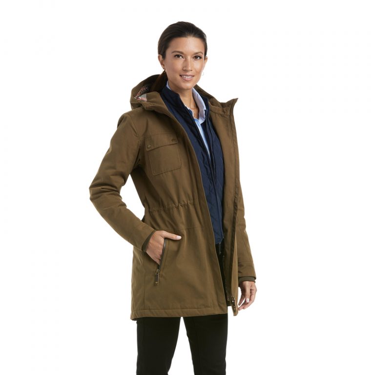 Woman modeling Ariat Argentium Parka in olive green with hood, layered over navy jacket and light blue shirt